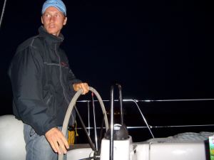Skipper Steffen Lelewel am Steuer einer Segelyacht bei Nacht